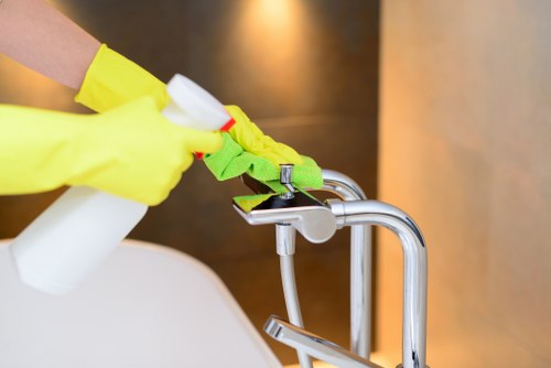 Professional home cleaner tidying a Fulham living room
